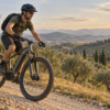 Illustrazione di un ciclista su e-MTB lungo uno sterrato collinare